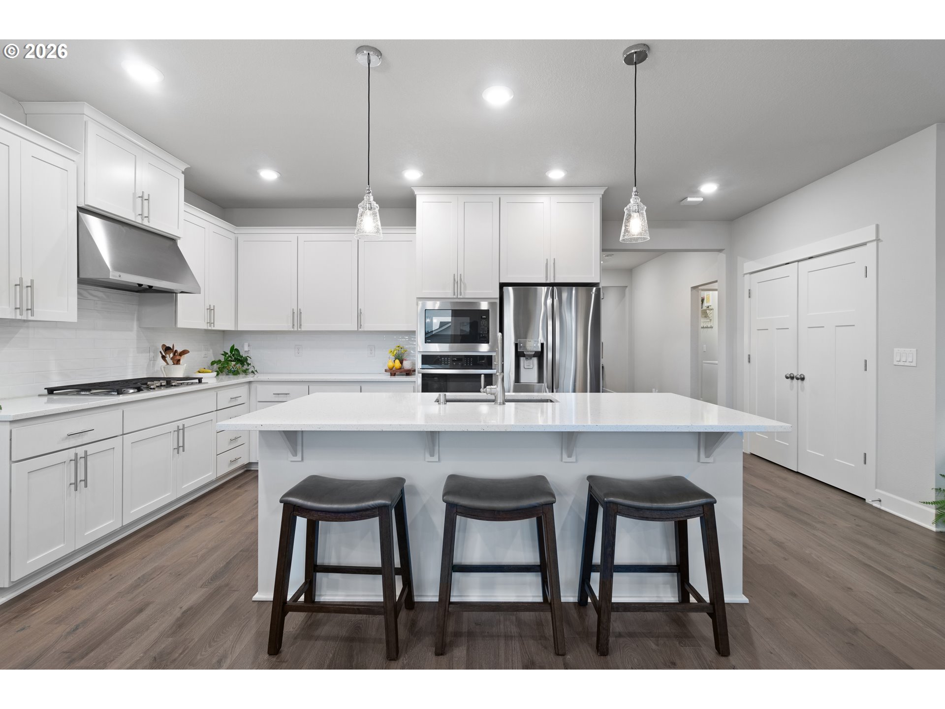 4935 South 16th Drive Ridgefield, WA 98642 - Photo 16 of 47 a kitchen with stainless steel appliances a dining table chairs refrigerator and microwave