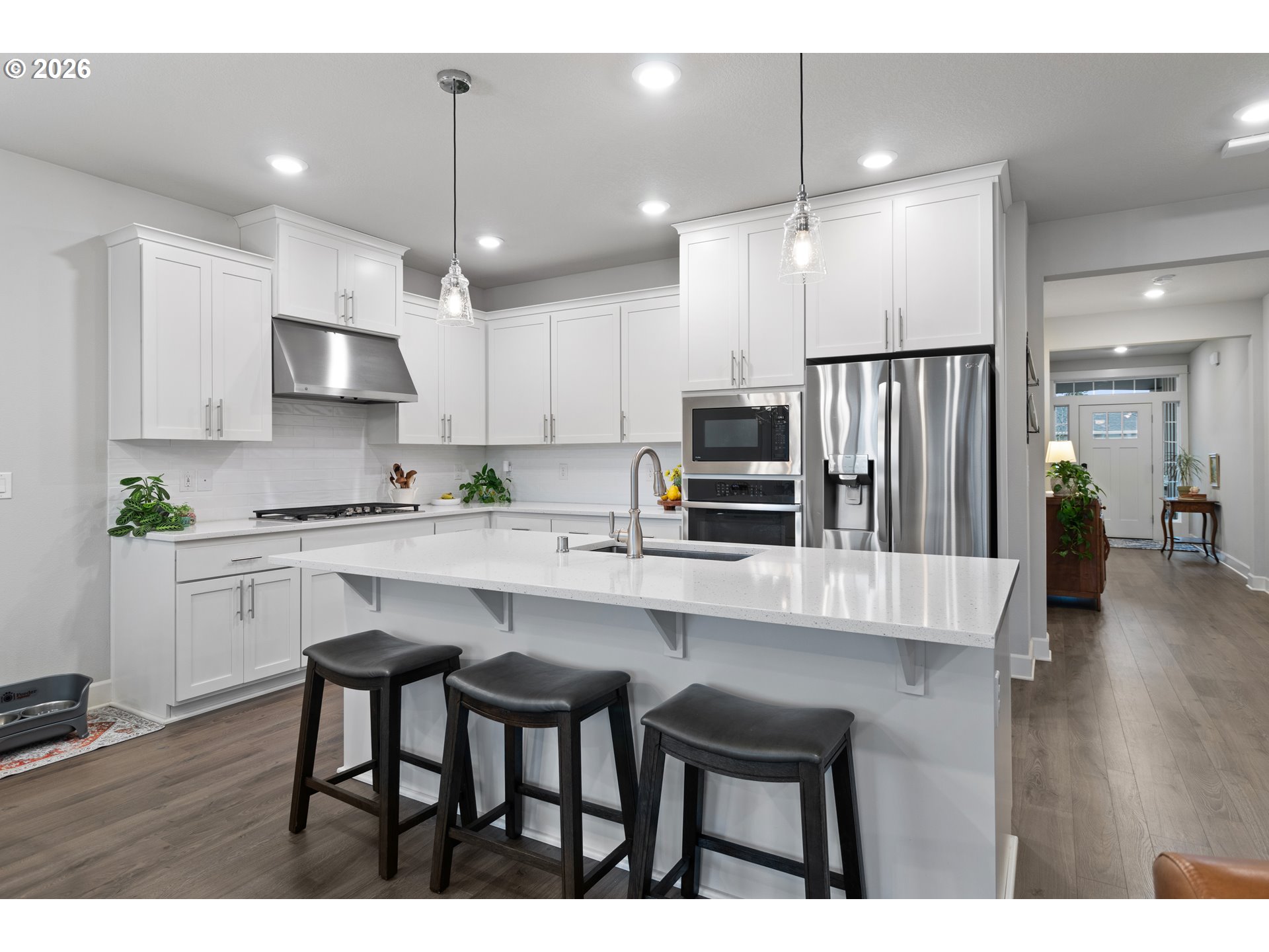 4935 South 16th Drive Ridgefield, WA 98642 - Photo 17 of 47 a kitchen with kitchen island granite countertop a table chairs refrigerator and microwave