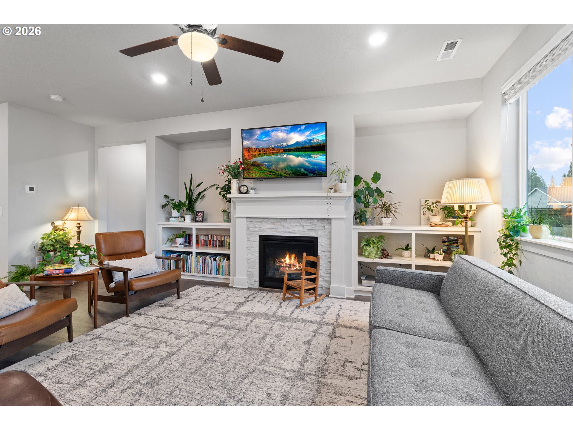 4935 South 16th Drive Ridgefield, WA 98642 - Photo 10 of 47 a living room with furniture a flat screen tv and a fireplace