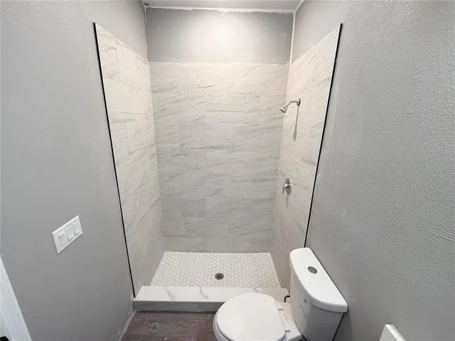 a white toilet sitting next to a bath tub