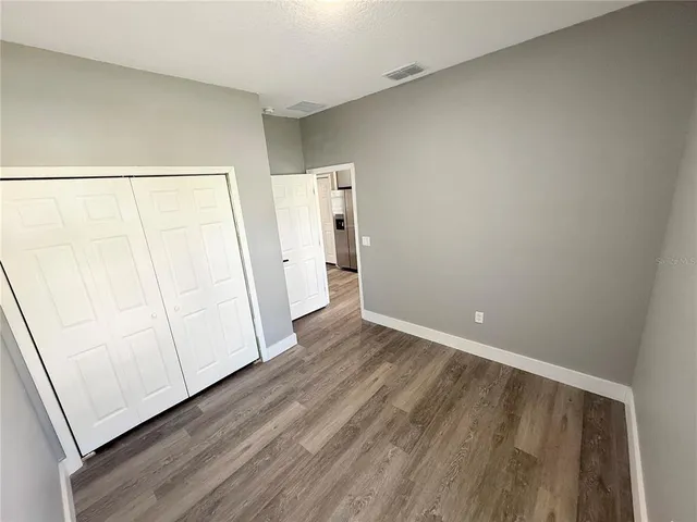 an empty room with wooden floor and white wall
