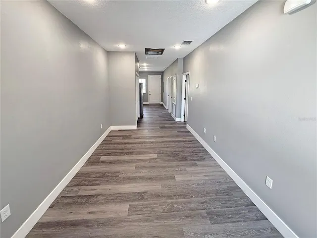 a view of a hallway with wooden floor
