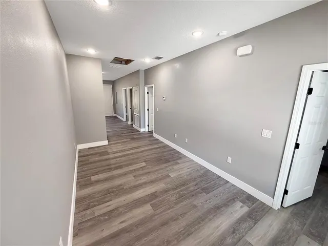 a view of a hallway with wooden floor and entryway