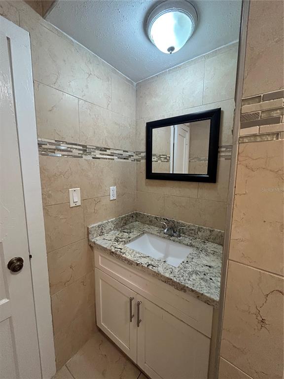 48 East Par Street Orlando, FL 32804 - Photo 12 of 25 a bathroom with a granite countertop sink and a mirror