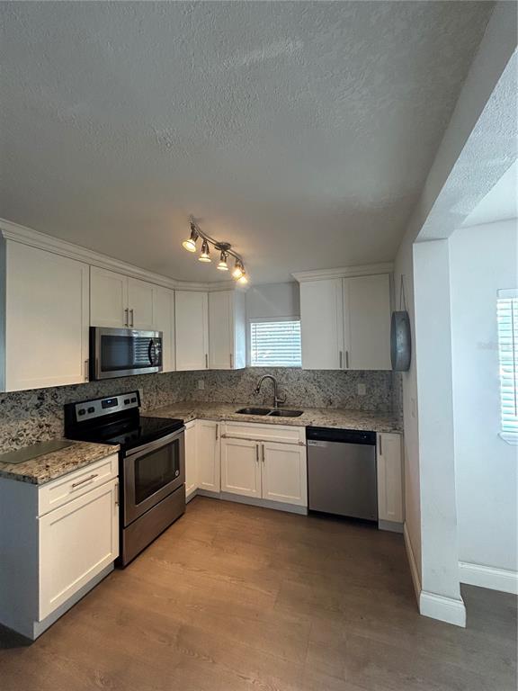 48 East Par Street Orlando, FL 32804 - Photo 6 of 25 a kitchen with stainless steel appliances granite countertop a stove top oven a sink and dishwasher