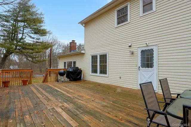 a view of a house with wooden deck and furniture