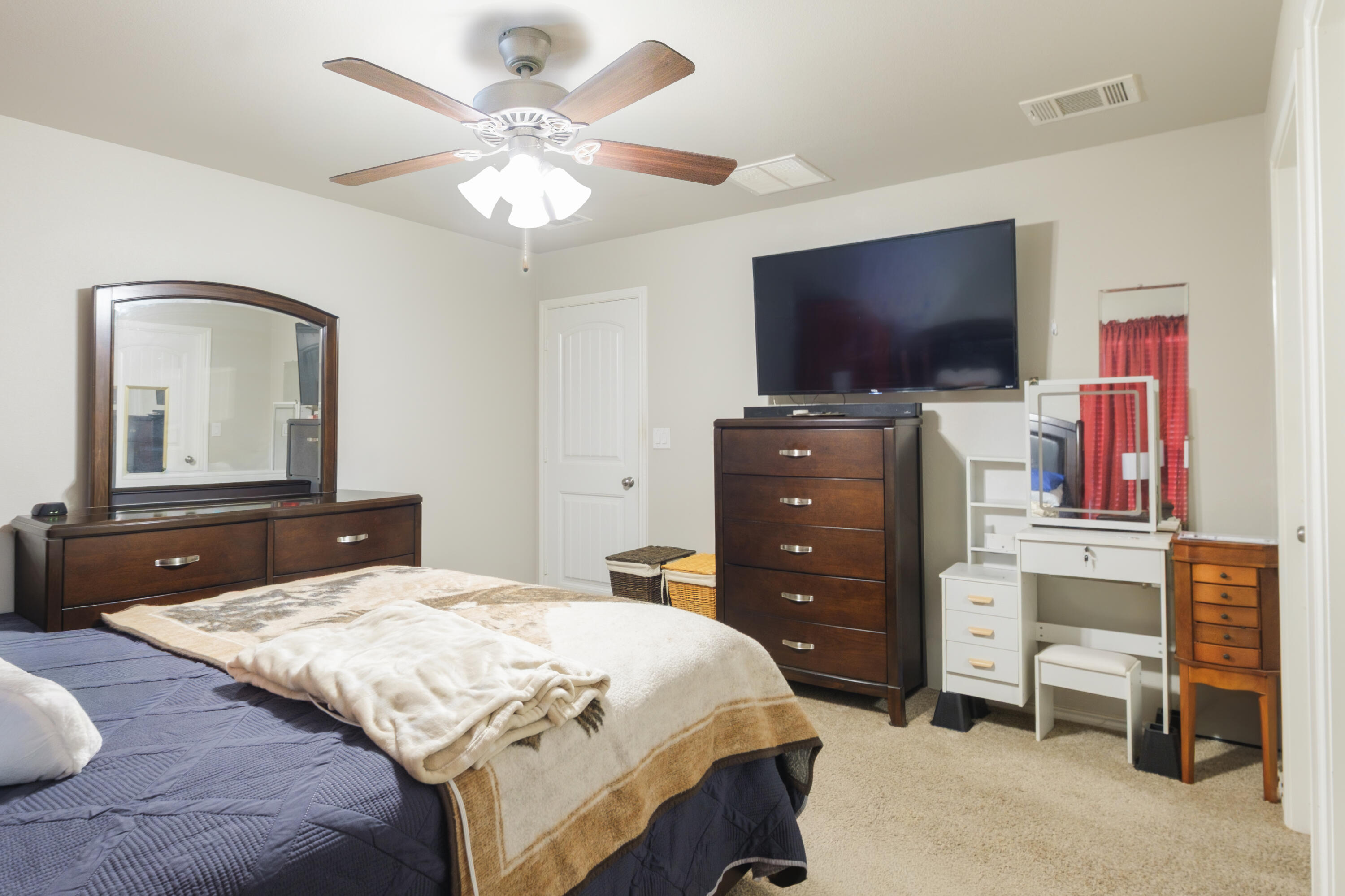 6821 39th Street Lubbock, TX 79407 - Photo 11 of 25 a bedroom with a bed and a flat screen tv