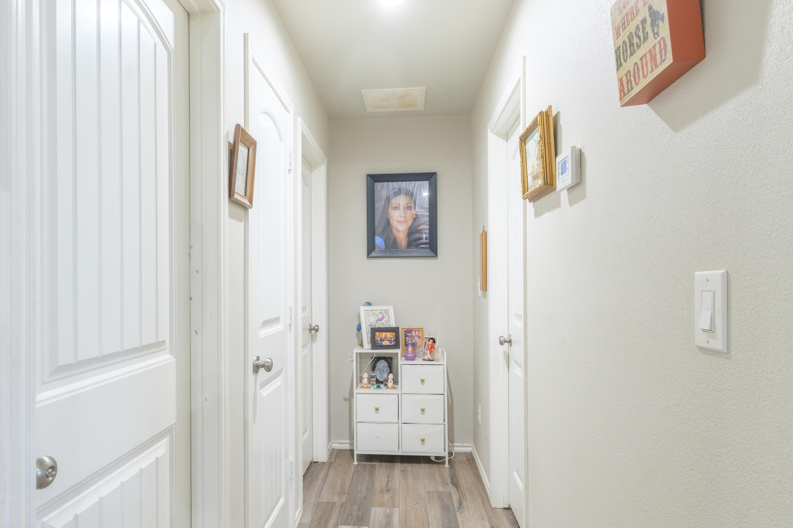 6821 39th Street Lubbock, TX 79407 - Photo 14 of 25 a view of a hallway with wooden floor and closet