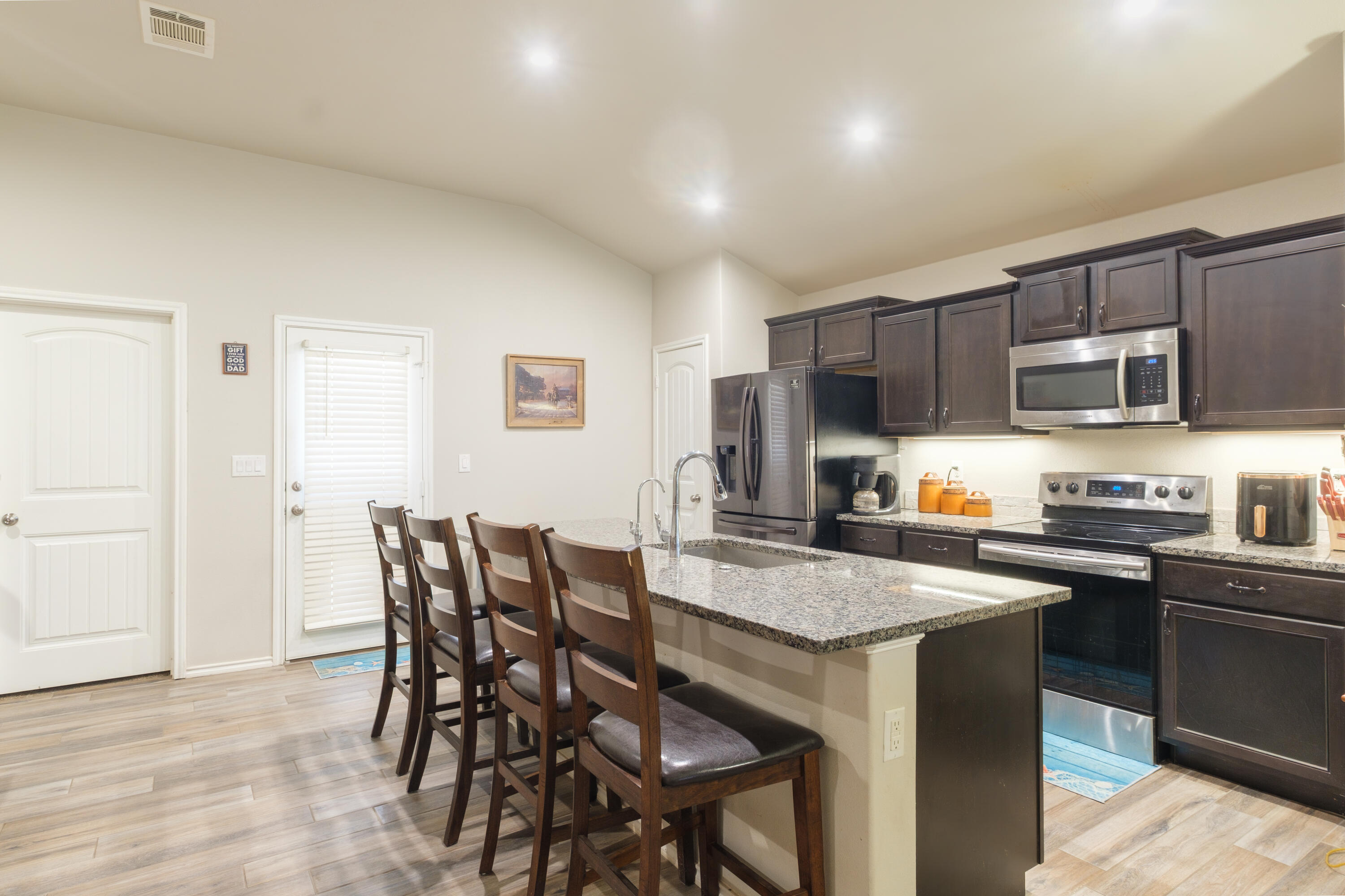 6821 39th Street Lubbock, TX 79407 - Photo 6 of 25 a kitchen with stainless steel appliances granite countertop a table chairs microwave and sink