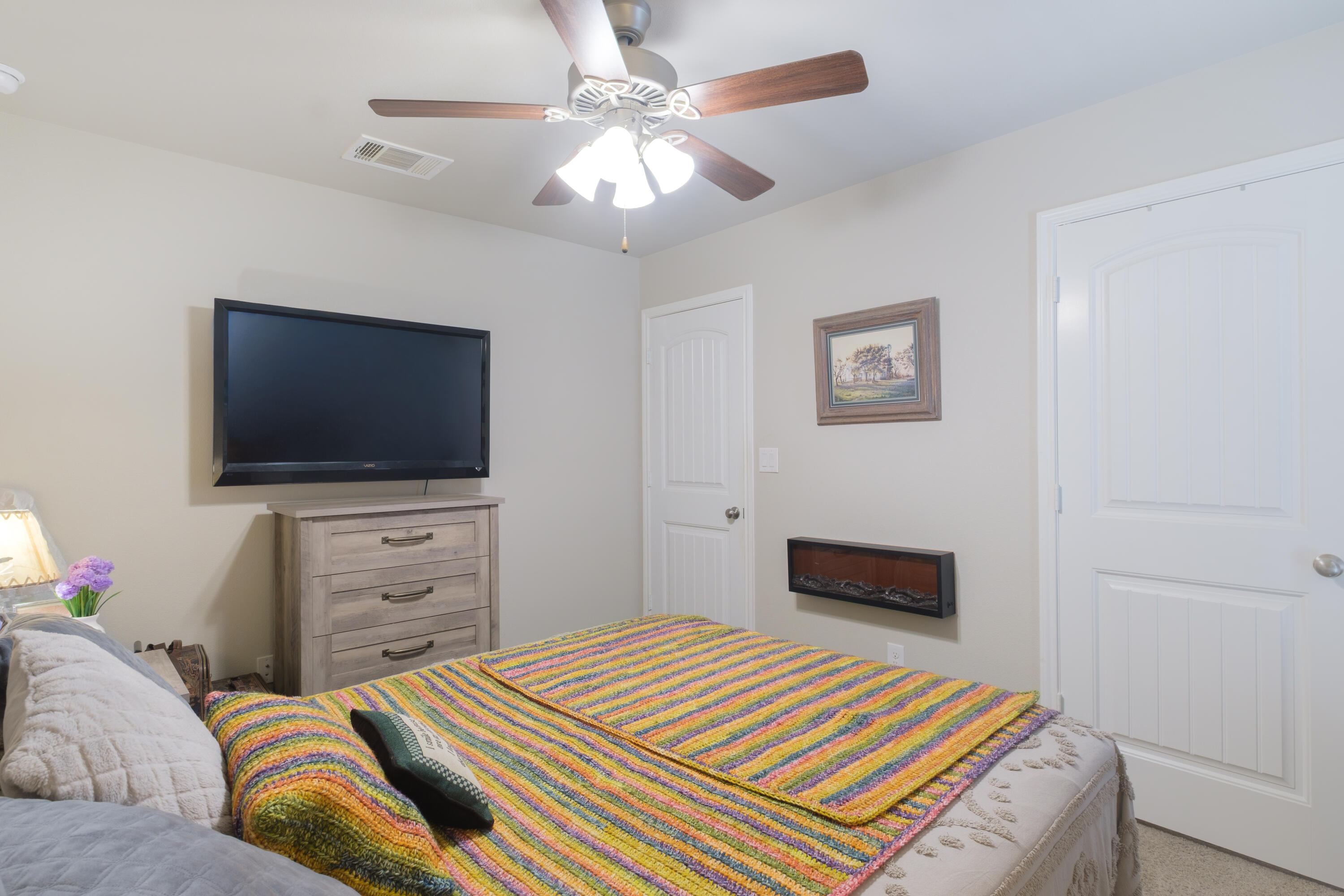 6821 39th Street Lubbock, TX 79407 - Photo 10 of 25 a bedroom with a bed and a flat screen tv