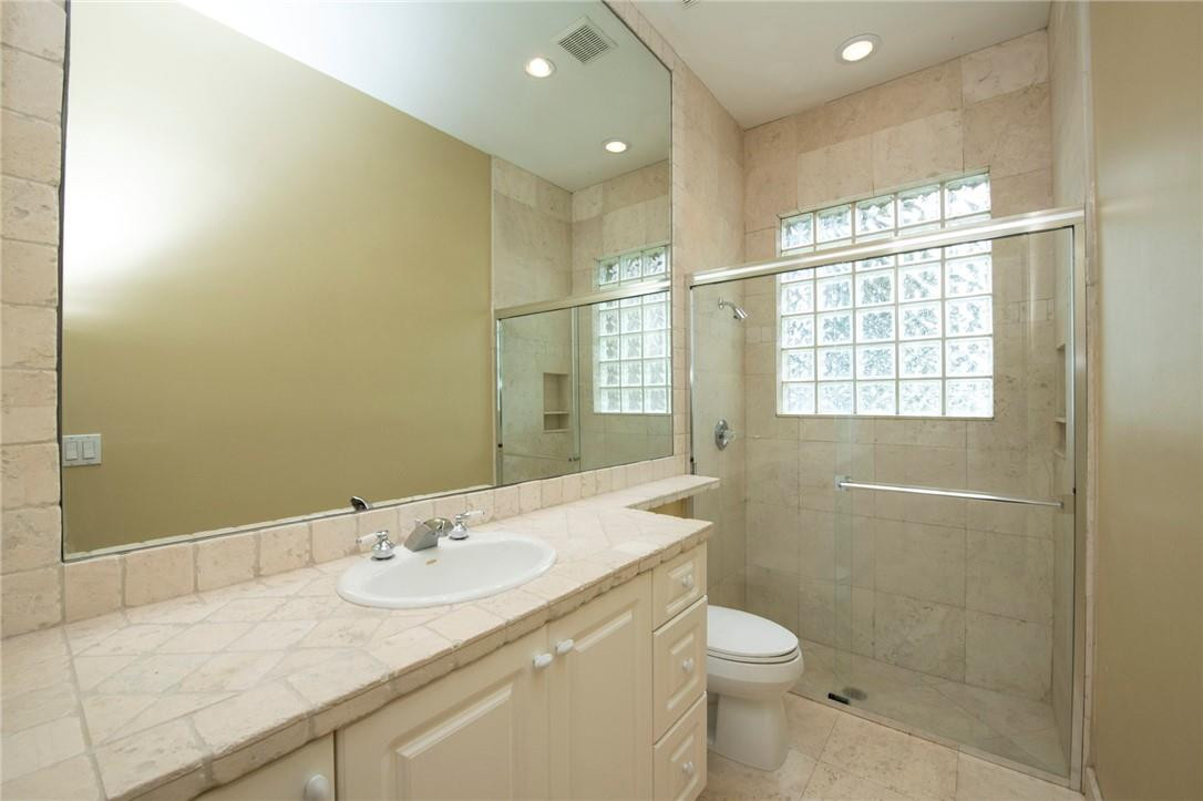 6468 Northwest 31st Way Boca Raton, FL 33496 - Photo 22 of 43 a bathroom with a granite countertop sink a toilet and shower