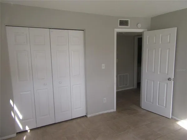 a view of an empty room with closet area