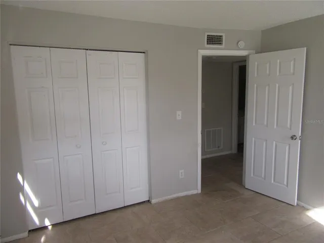 a view of an empty room with closet area
