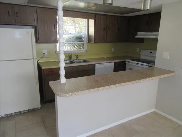 a kitchen with granite countertop a refrigerator and a sink