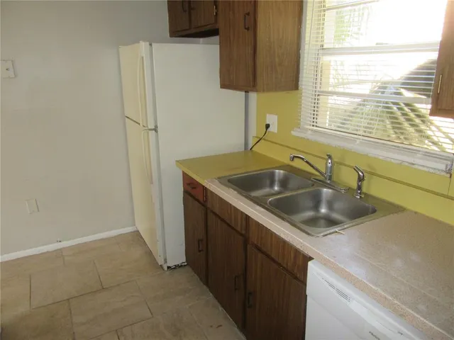 a kitchen with a sink a refrigerator and window