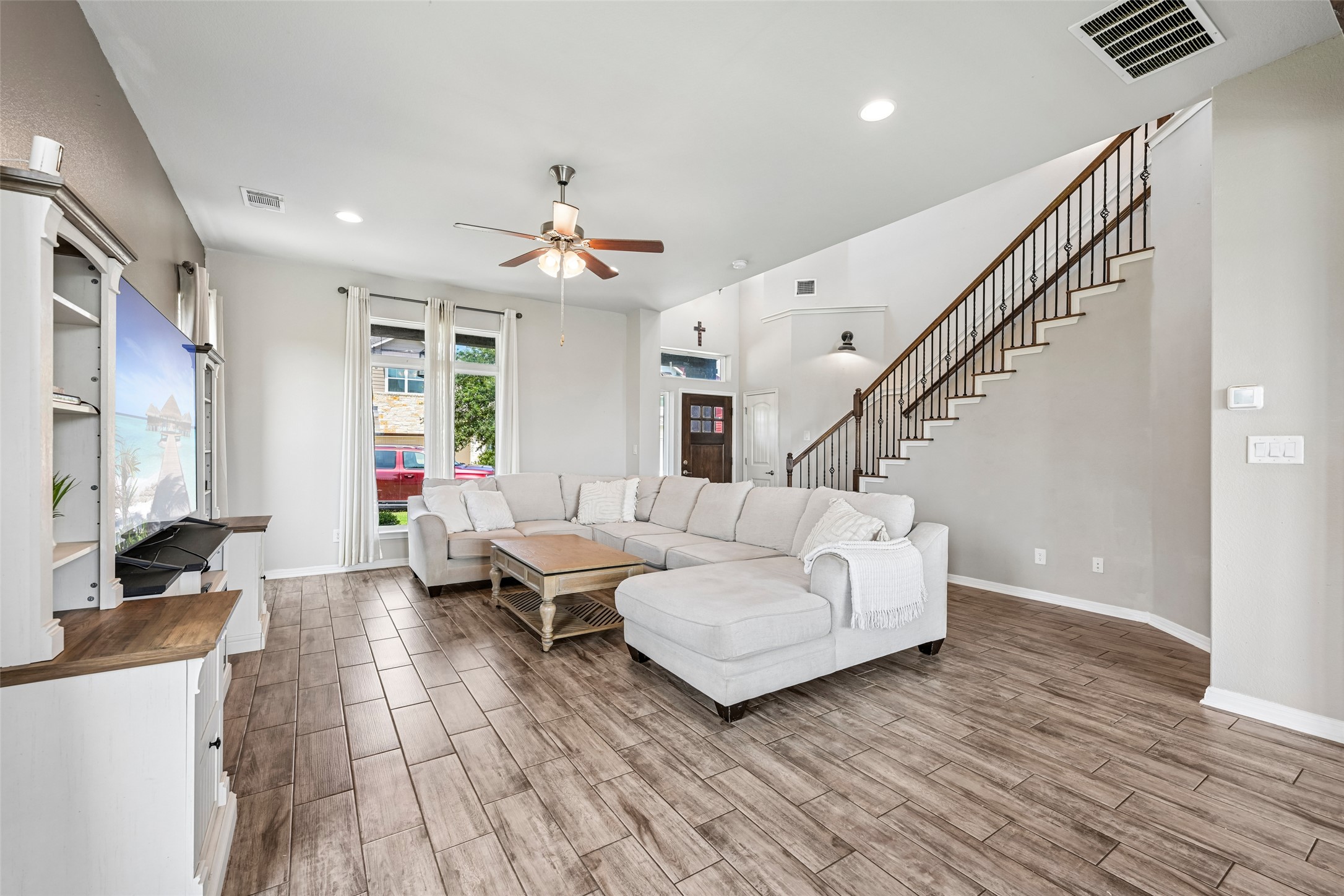 1297 Harwell Loop Kyle, TX 78640 - Photo 7 of 39 A welcoming entryway with warm wood-look flooring leads to a spacious living area and an elegant staircase.