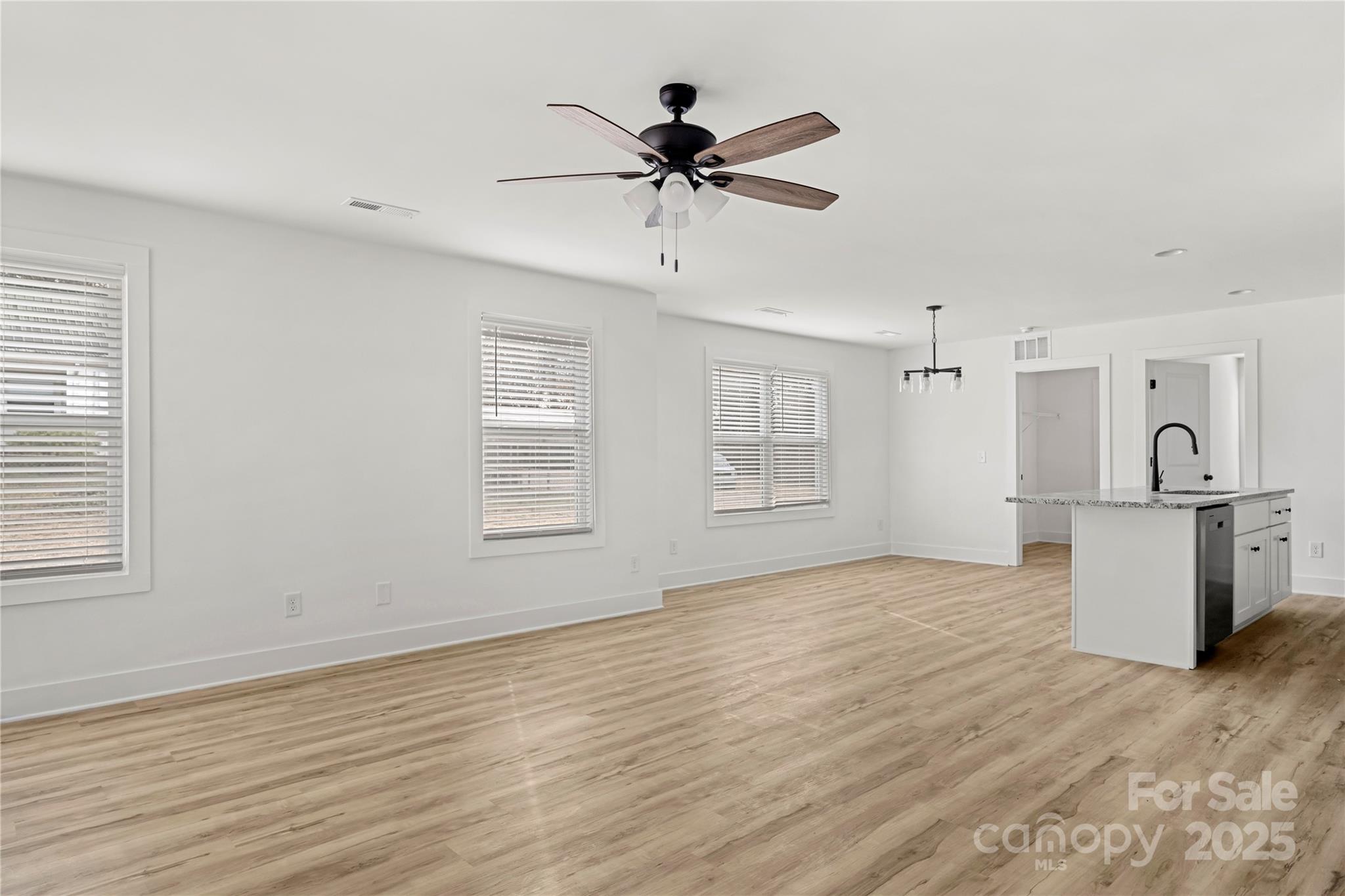 2022 4th Street Southwest Hickory, NC 28602 - Photo 2 of 31 an empty room with wooden floor a ceiling fan and windows