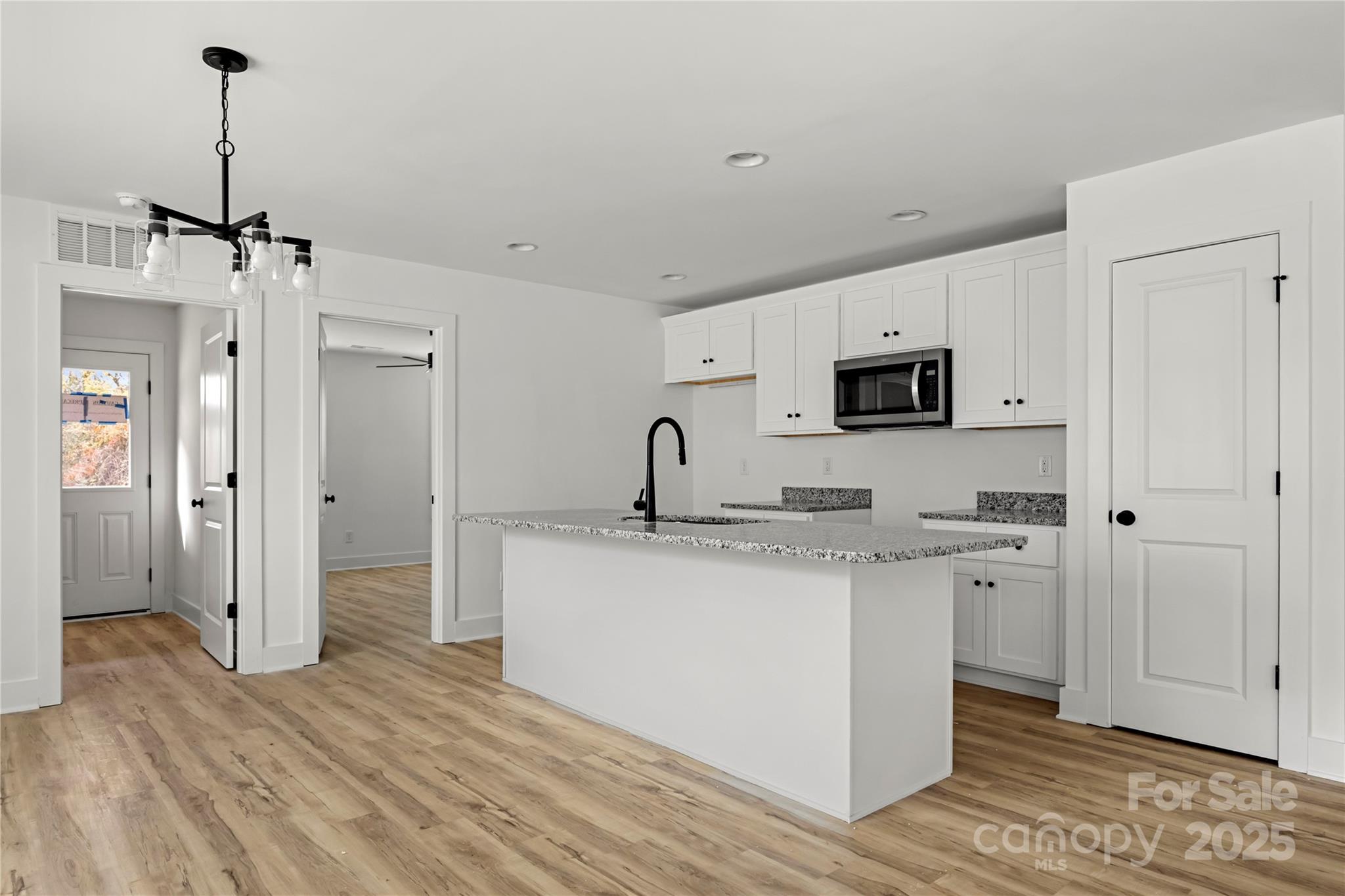 2022 4th Street Southwest Hickory, NC 28602 - Photo 8 of 31 a kitchen with stainless steel appliances granite countertop a sink a stove a refrigerator and white cabinets with wooden floor