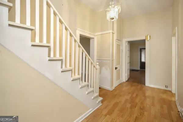a view of staircase with lots of frames on wall and a chandelier
