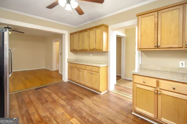 a view of a kitchen with wooden floor and a refrigerator