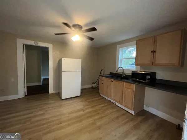 a kitchen with sink a refrigerator and white cabinets