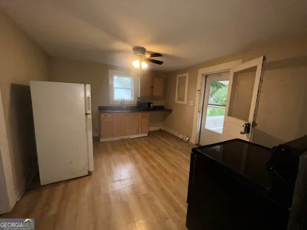 a kitchen with a refrigerator and wooden floor