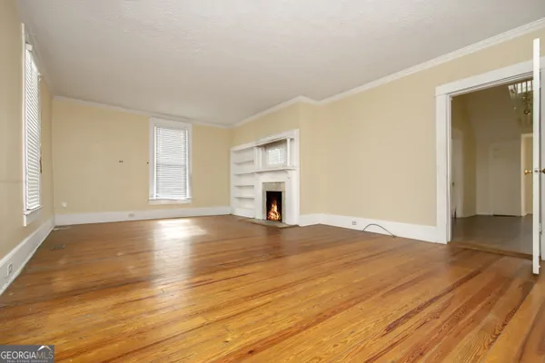a view of empty room with wooden floor and fireplace