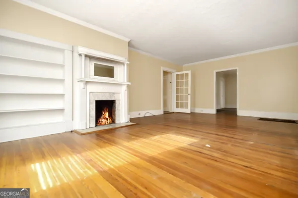 a view of empty room with wooden floor and fireplace