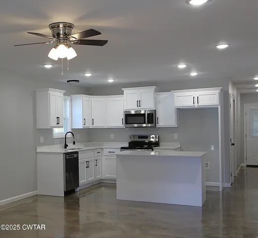 a kitchen with a sink stainless steel appliances and white cabinets