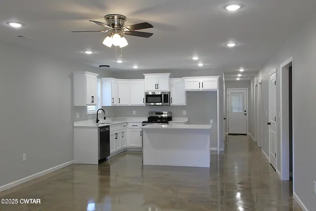 a kitchen with kitchen island a sink stainless steel appliances and cabinets