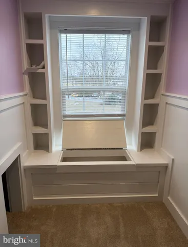 a view of an empty room with a fireplace and a window