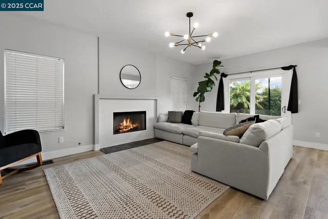 a living room with furniture a chandelier and a window