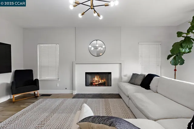 a kitchen with white cabinets and wooden floor