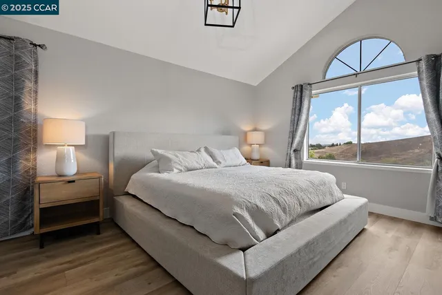 a bedroom with a bed a mirror and a window