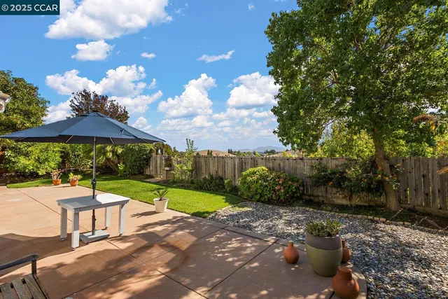 a view of a house with backyard and sitting area