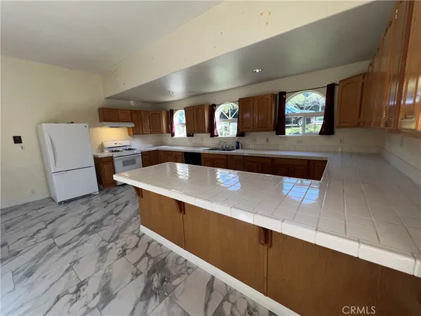 a view of kitchen with a sink and refrigerator