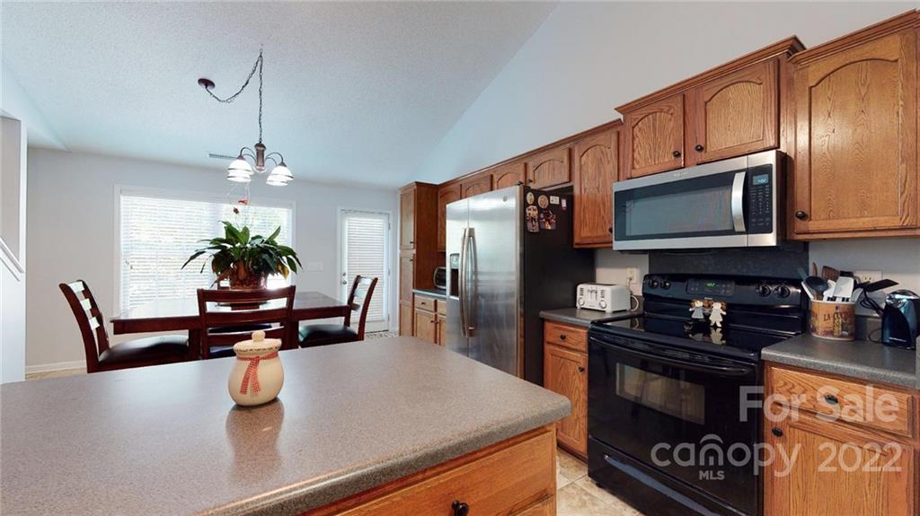 1447 George Dunn Road Rock Hill, SC 29730 - Photo 20 of 44 a kitchen with stainless steel appliances a sink a stove a microwave a refrigerator cabinets and a dining table