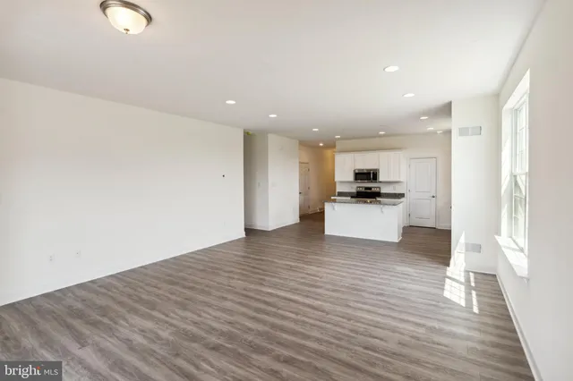 a view of a kitchen with a sink and dishwasher a refrigerator with wooden floor