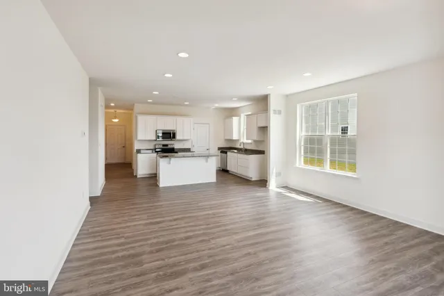 a view of an empty room with kitchen appliances and a window