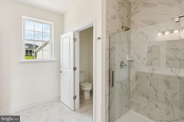 a bathroom with a granite countertop shower and a sink