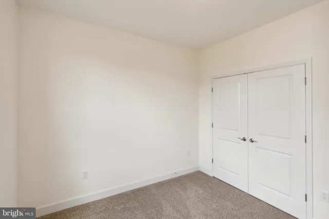 an empty room with white wall and closet