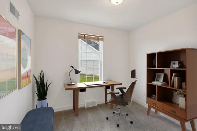 a view of a workspace with furniture and a window