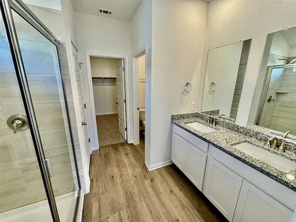 a kitchen with stainless steel appliances granite countertop a refrigerator a stove a sink and a microwave with wooden floor