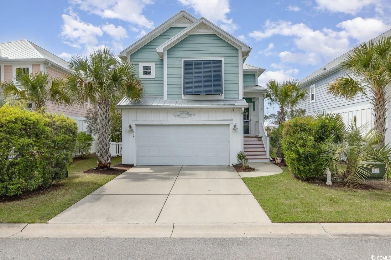 View of front of home with driveway and an attached garage