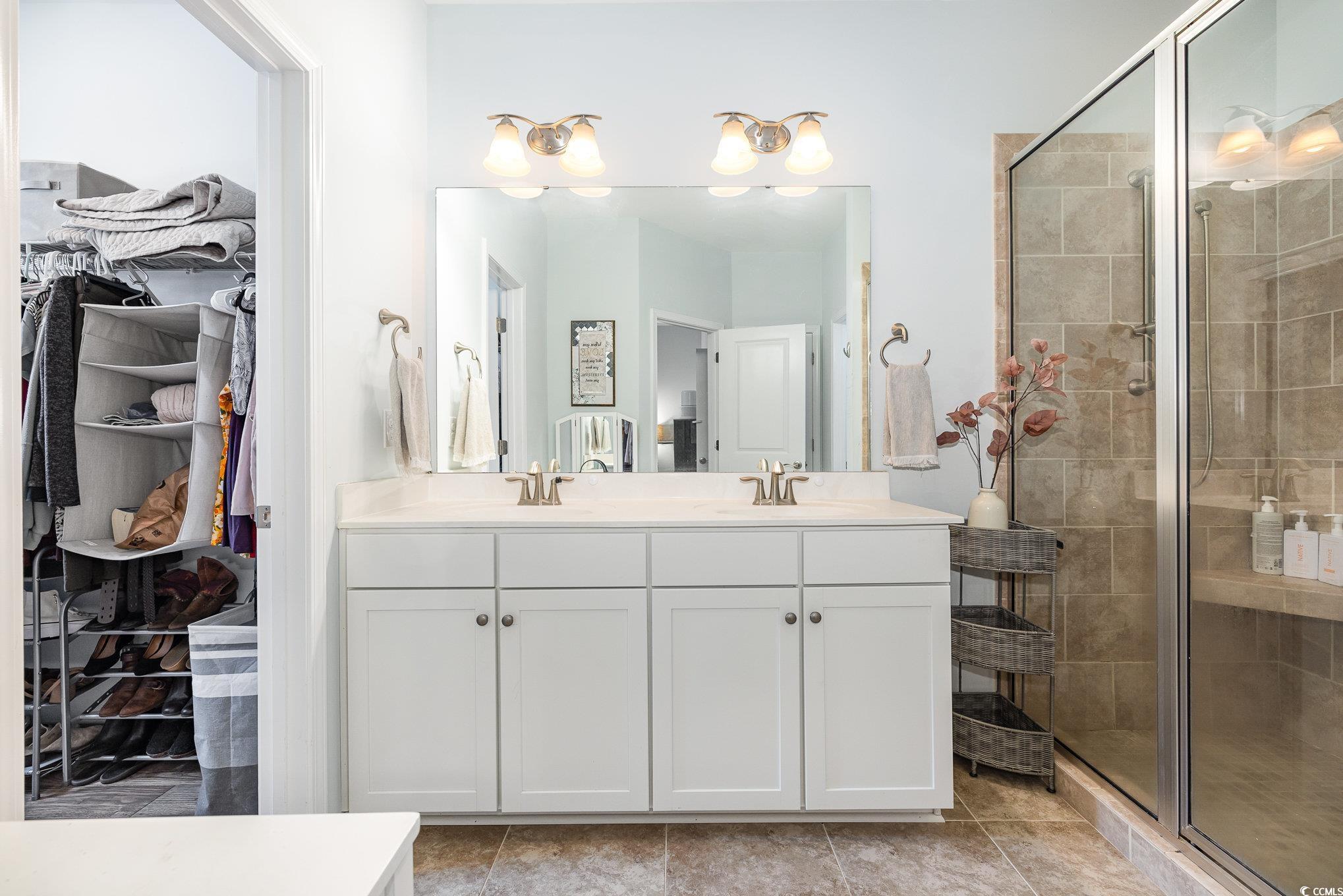 136 Splendor Circle Murrells Inlet, SC 29576 - Photo 12 of 30 Bathroom featuring a shower stall, double vanity, a spacious closet, and a sink