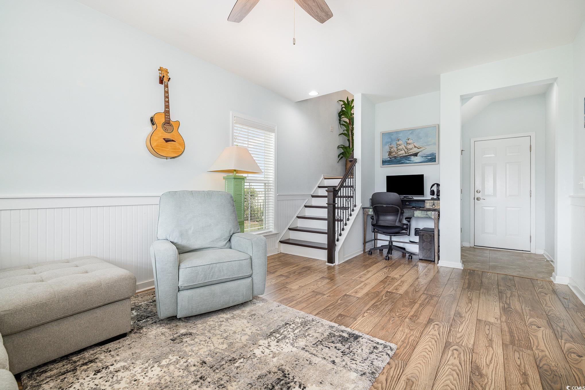 136 Splendor Circle Murrells Inlet, SC 29576 - Photo 4 of 30 Sitting room with stairs, wood finished floors, a ceiling fan, and wainscoting