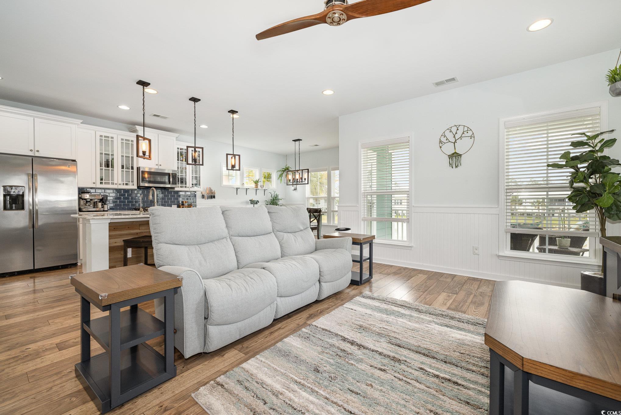 136 Splendor Circle Murrells Inlet, SC 29576 - Photo 5 of 30 Living room featuring visible vents, ceiling fan, light wood-type flooring, and wainscoting