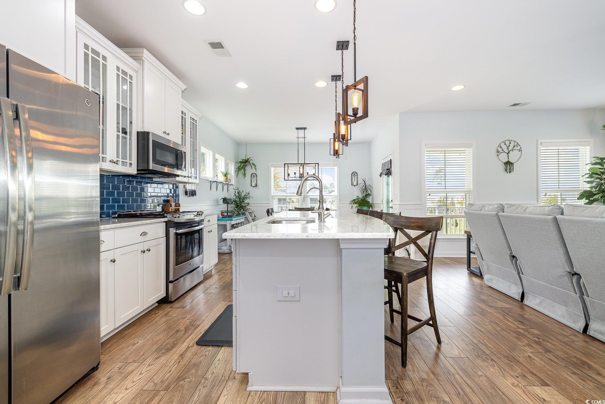 136 Splendor Circle Murrells Inlet, SC 29576 - Photo 9 of 30 Kitchen featuring visible vents, a breakfast bar, stainless steel appliances, a center island with sink, and a sink