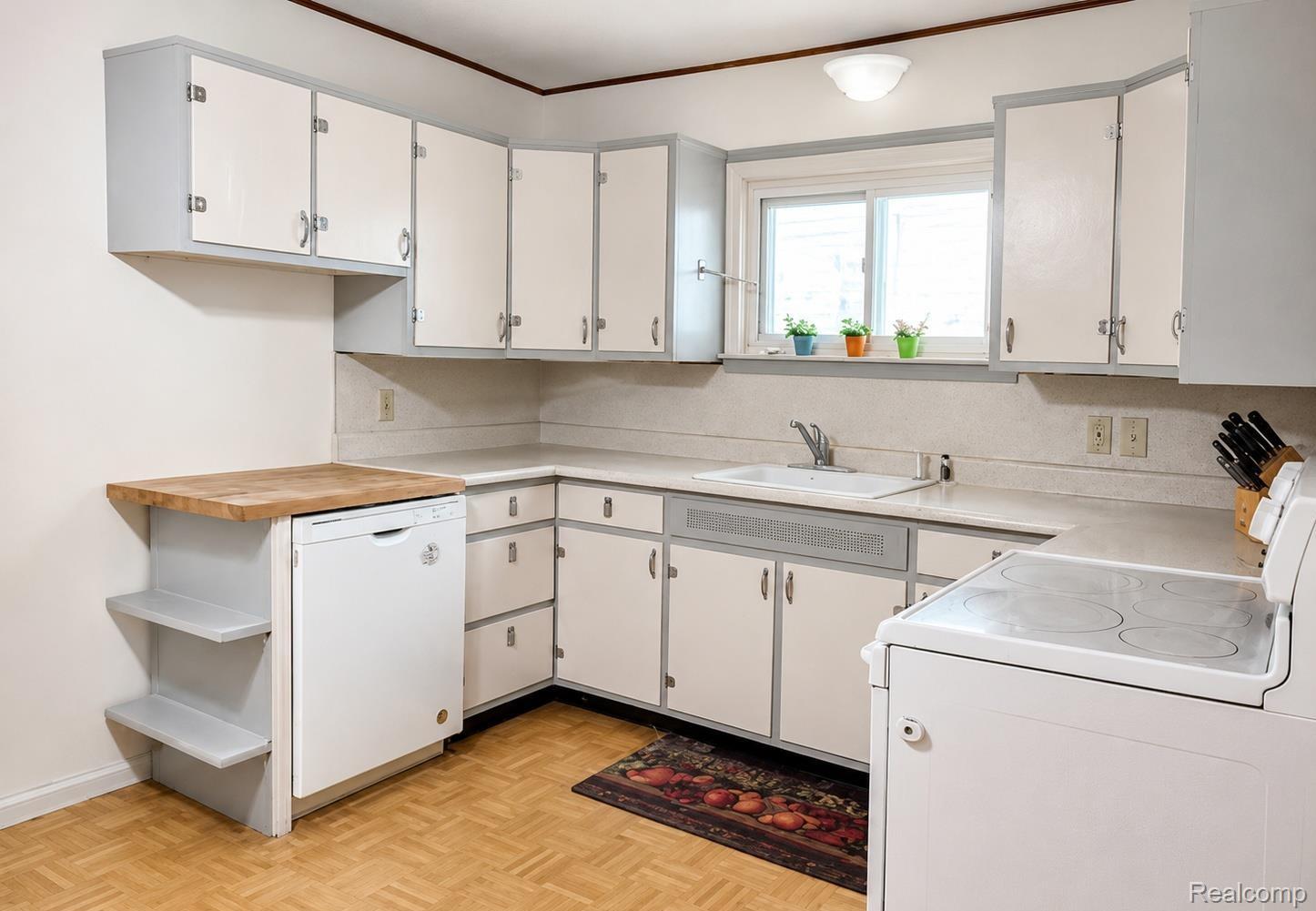9552 Wayne Road Livonia, MI 48150 - Photo 7 of 31 Immaculately maintained and full of retro charm, this fabulous kitchen showcases crisp vintage cabinetry, clean neutral finishes, and beautiful parquet flooring that adds warmth and character