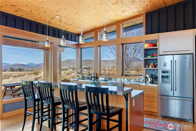 a kitchen with stainless steel appliances wooden floor and a refrigerator